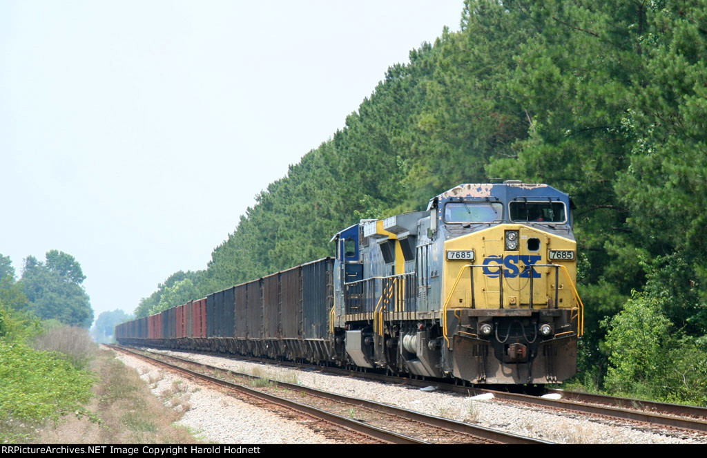 CSX 7685 is on the lead of a rock train in a siding